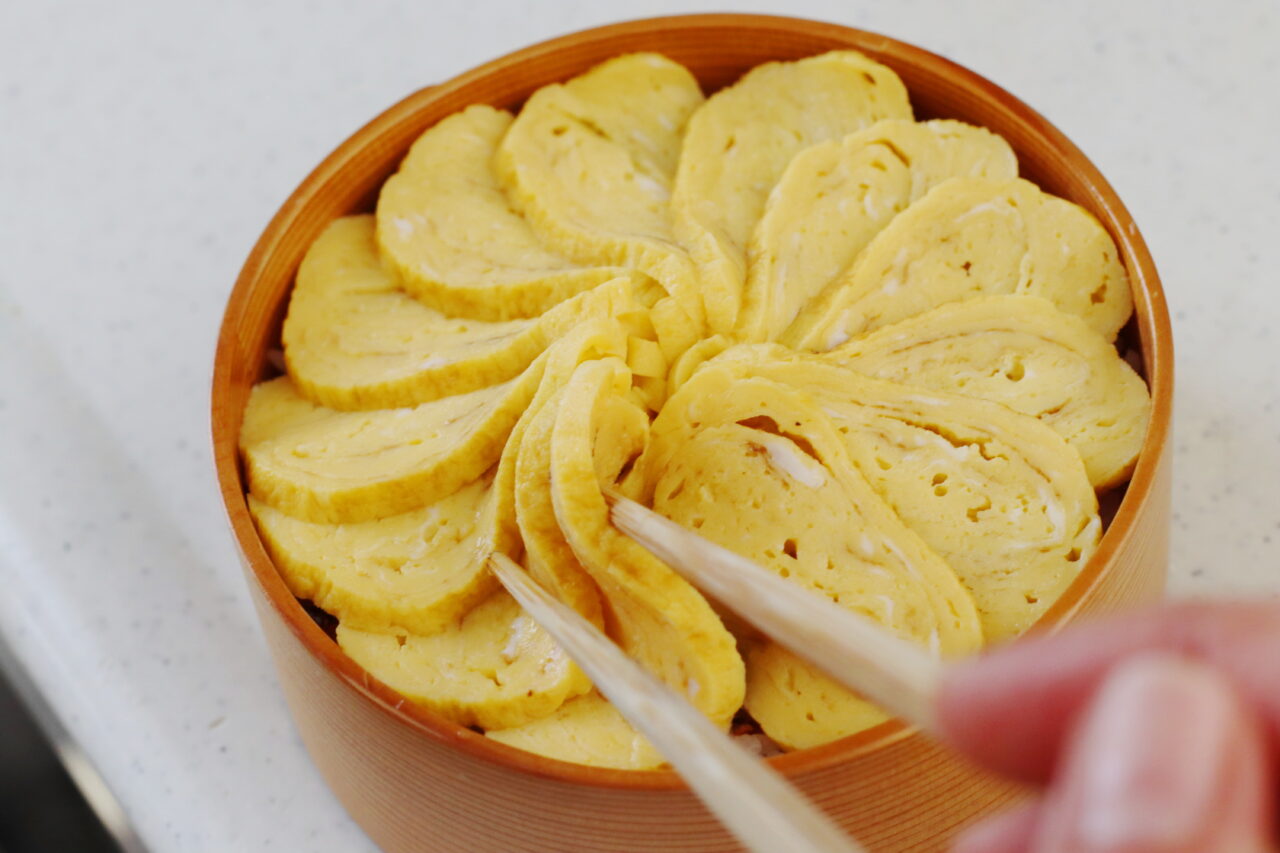 料理家かめ代。
kameyo
2品弁当
卵焼きを薄切りにした菊の花のような卵焼き丼

の画像です。